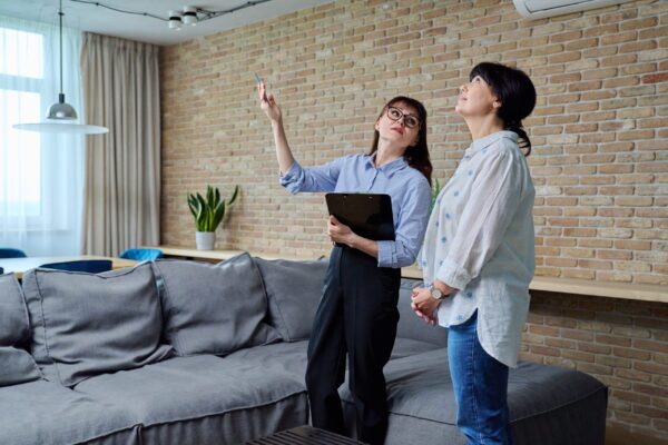 Female real estate agent showing apartment, house, to buyer, tenant Confident female real estate agent showing apartment house mature female to buyer tenant. Female realtor with clipboard showing furnished modern living room. Sale moving home renting property business